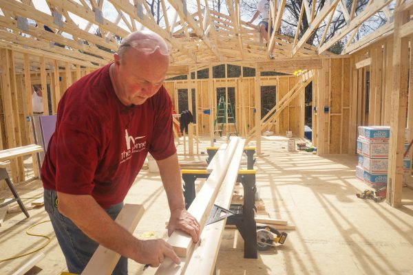GPC volunteer Jay Setliff makes the measurements of a piece of wood during a home rebuild project.