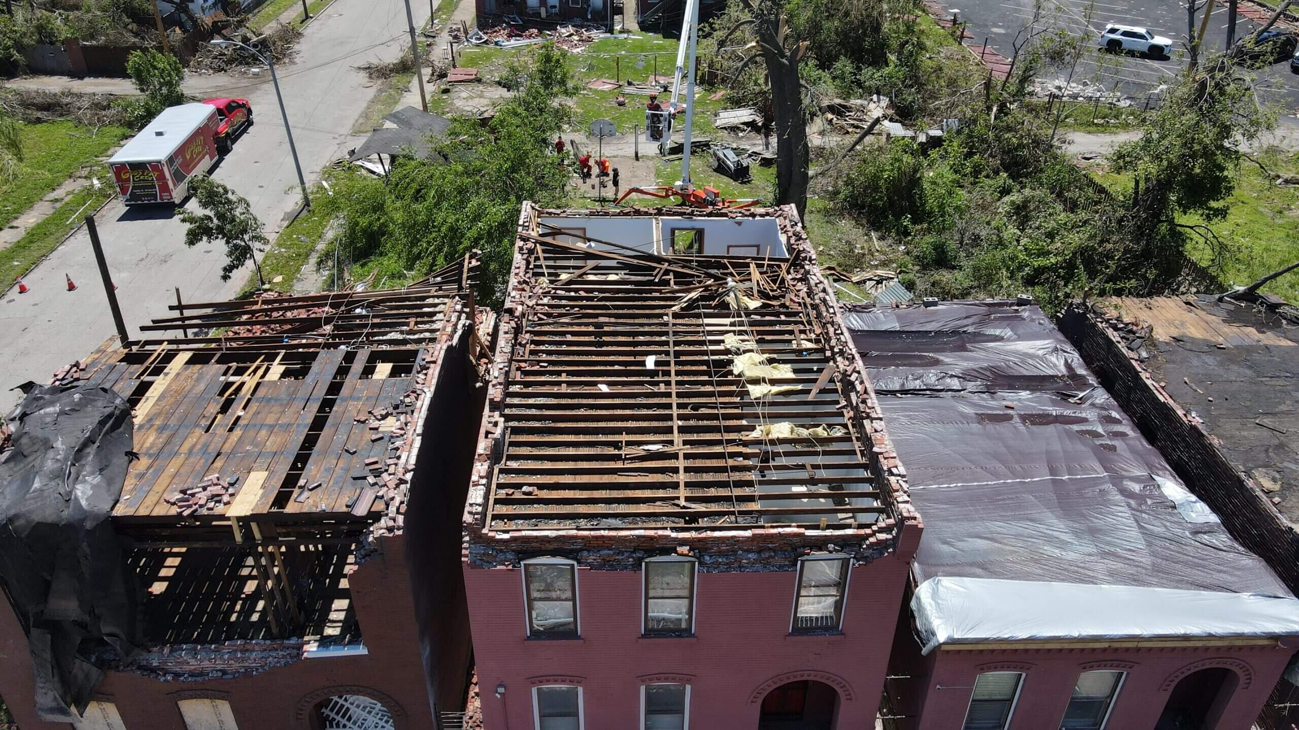 A damaged building with a partially collapsed roof and scattered debris.