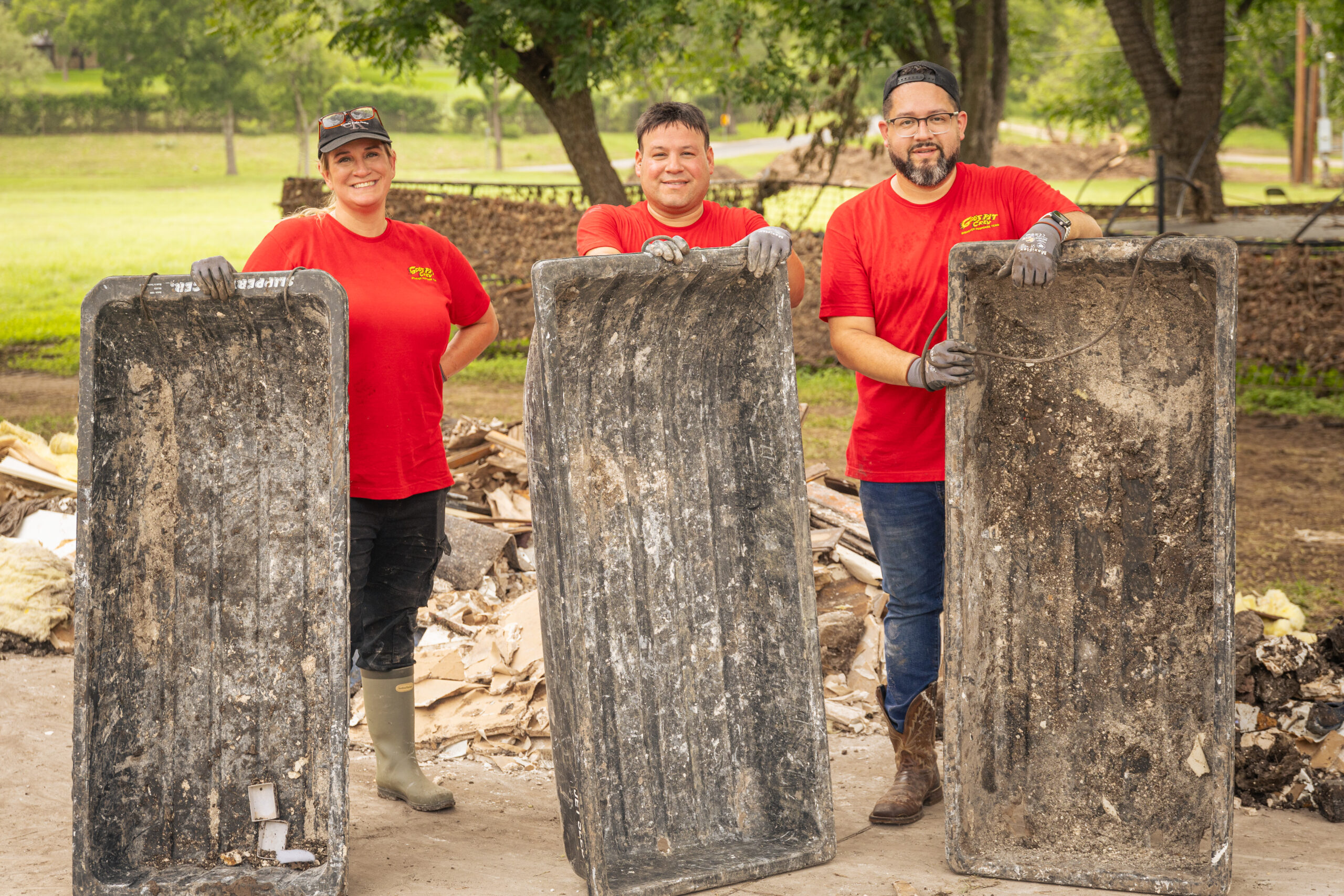 Three men holding large stone tablets outdoors.