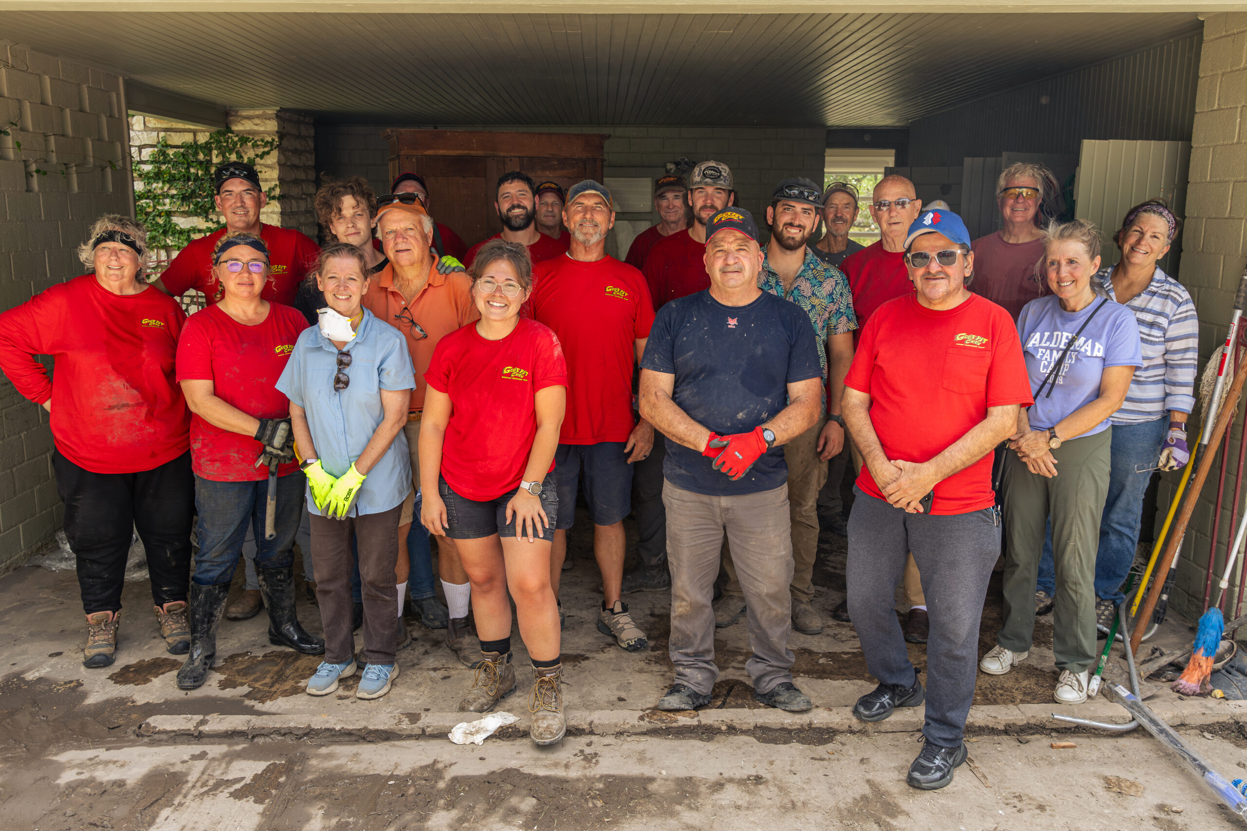 Group photo of people in red shirts and casual wear posing indoors.